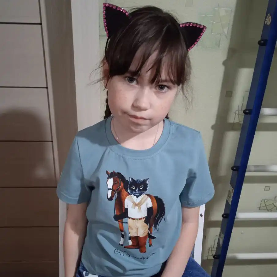 Girl wearing cat ears and a cat-themed shirt.